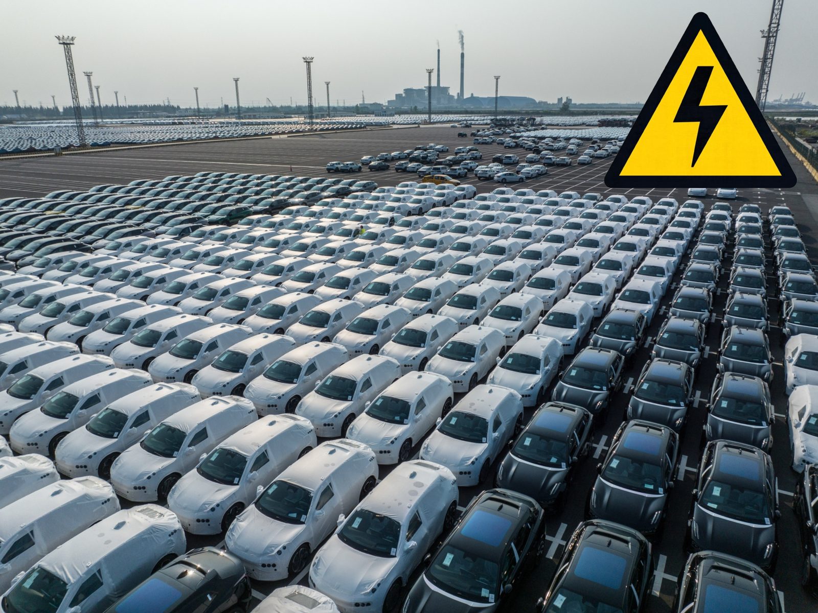 Grande pátio com milhares de veículos elétricos novos prontos para distribuição
